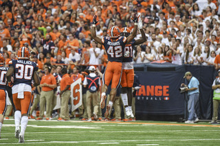 Two Syracuse defenders celebrate a big play during SU's loss to No. 1 Clemson.