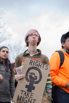 A community member holds a sign that reads 