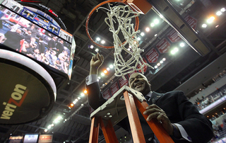 Head coach John Thompson III of the Georgetown Hoyas cheers with the crowd as he cuts down the net after a win over the Syracuse Orange clinched a Big East regular-season championship for Georgetown.