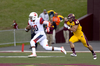 Syracuse quarterback Terrel Hunt glides by CMU defensive end Joe Ostman into the open field.