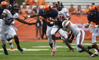 Ameen-Moore throws a stiff arm at a UofL defender while anticipating contact from another.