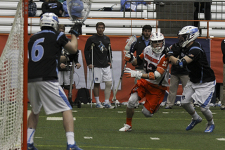 Sophomore midfielder Jordan Evans dodges toward the goal with a JHU defender guarding closely.