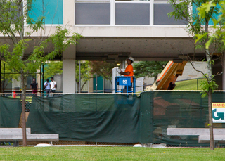 A construction worker puts finishing touches on the ceiling of the DellPlain Hall breezeway. Work is expected to be finished before students move-in for the fall semester. Photo taken Aug. 1, 2017