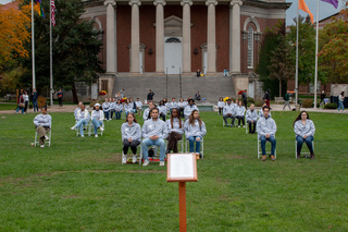 Flags wave in the cloudy sky in front of Hendricks Chapel as the Remembrance Scholars took their place for the event. Remembrance Scholars remained seated from 1:28 pm until 2:03 pm in commemoration of the 35 students’ lives lost on Pan Am Flight 103. 