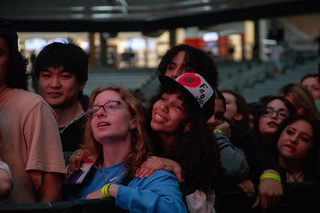 Audience members enjoy Webster’s music and each other’s company at Block Party. Some sported their free University Union hats from Block Darty, where UU offered students a chance to customize them with spray paint.